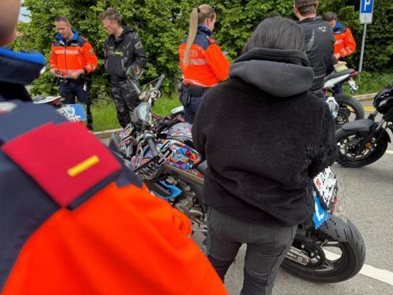 Polizisten kontrolliern Motorradfahrer und ihre Motorräder