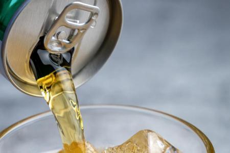 Ein Getränk wird in ein Glas mit Eis geleert.