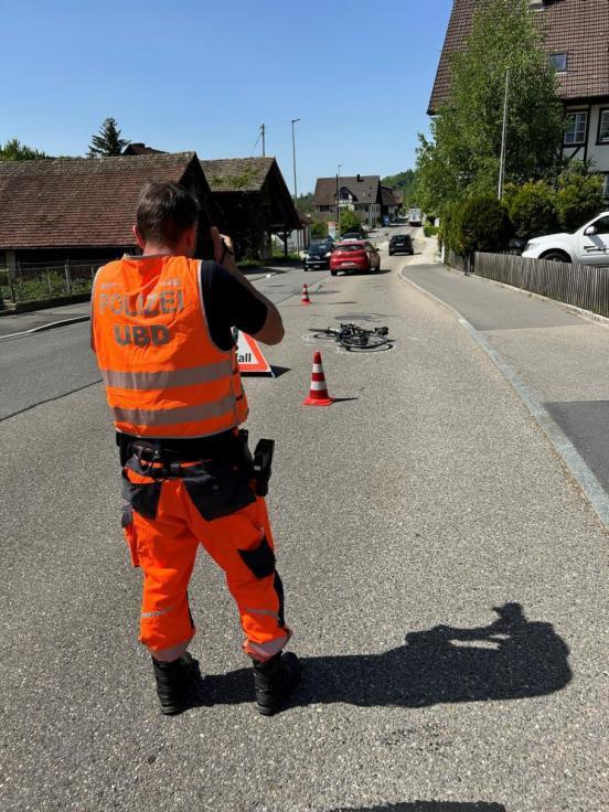 Ein Polizist fotografiert das am Boden liegende Fahrrad