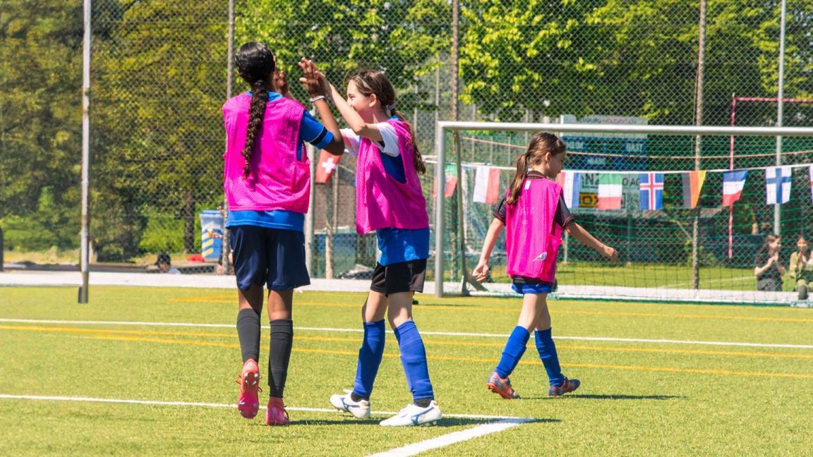 Zwei Mädchen klatschen sich auf dem Fussballplatz ab