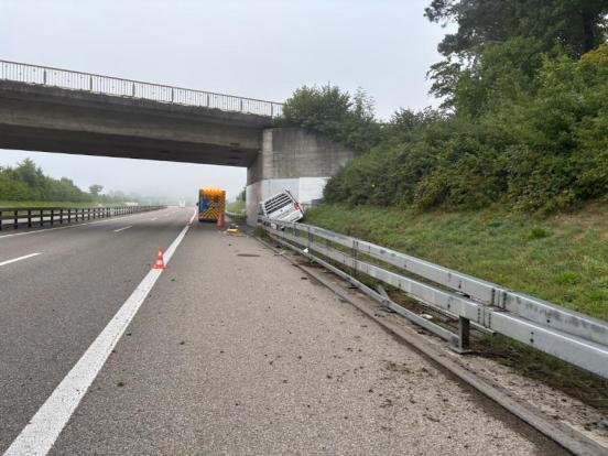 Unfallfahrzeug hinter der Leitplanke mit Brücke kollidiert