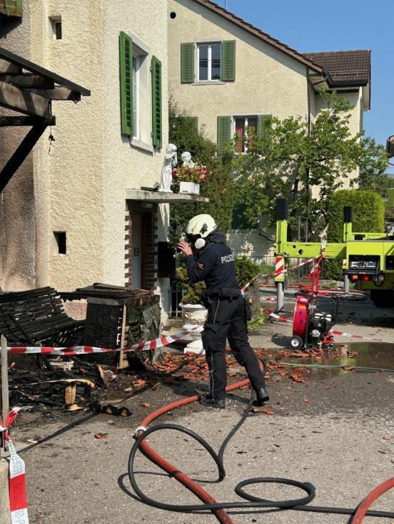 Ermittler der Polizei erstellt vor einem Haus Foto, das zuvor brante 