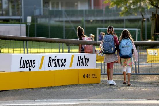 Schülerinnen laufen an einer Kampagnen Botschaft vorbei (Luege, Bräse, Halte)