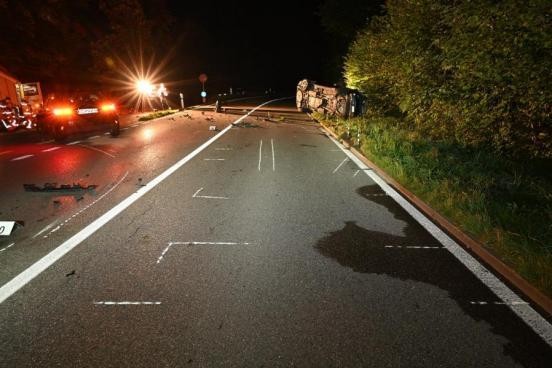 Ein Unfallfahrzeug steht linksseitig neben der Strasse. Ein weiteres liegt auf der Seite am rechten Fahrbahnrand.