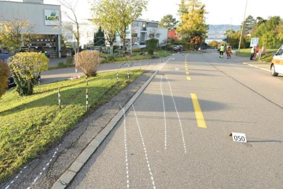 Unfallspuren und beschädigter Vorgarten; im Hintergrund das Unfallfahrzeug