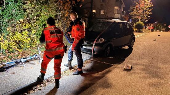 Zwei Polizisten beleuchten und fotografieren das Unfallfahrrad