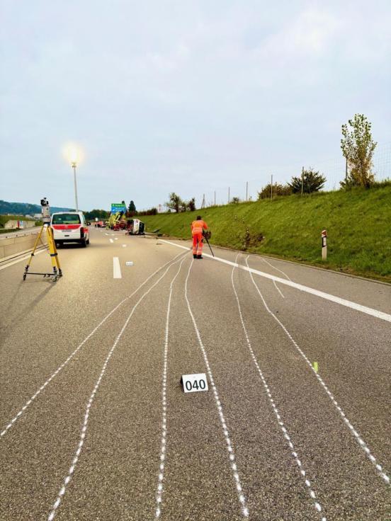 Übersichtsaufnahme der Autobahn. Im Vordergrund Driftspuren eingezeichnet, beschädigtes Auto im Hintergrund.