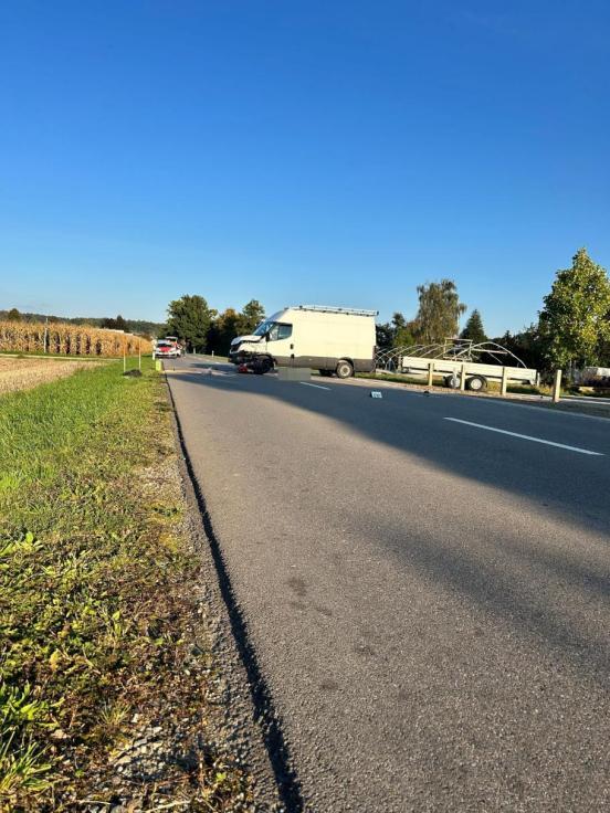 Ein weisser Lieferwagen steht quer auf der Fahrbahn, im vorderen Bereich liegt ein beschädigtes Motorrad am Boden.