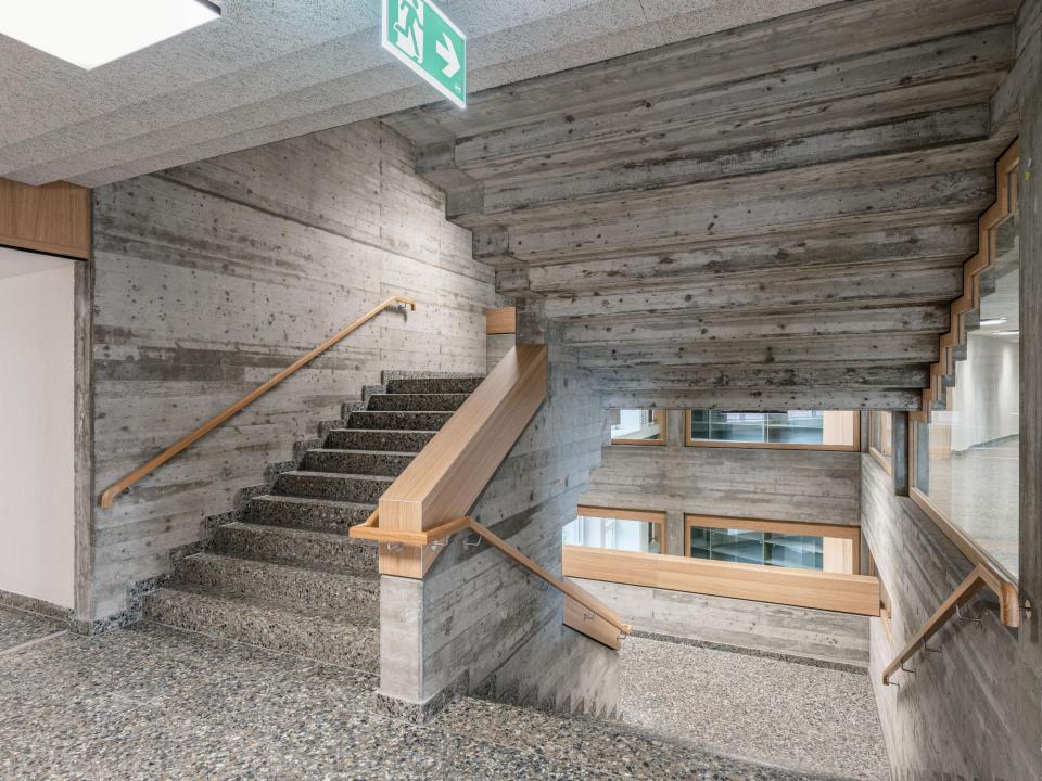 Markantes Treppenhaus aus Beton mit Holzelementen. 