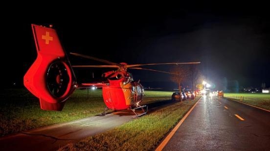 Ein roter Helikopter auf dem Radweg, im Hintergrund die Unfallszene