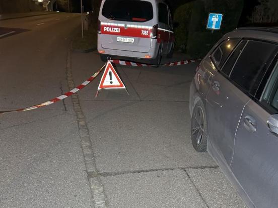 Ein Polizeiabsperrband mit Faltsignal vor einem Polizeifahrzeug