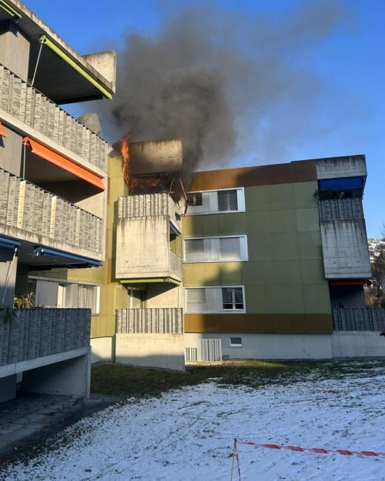 Vom Balkon im obersten Stock dringt dichter Rauch und Flammen.