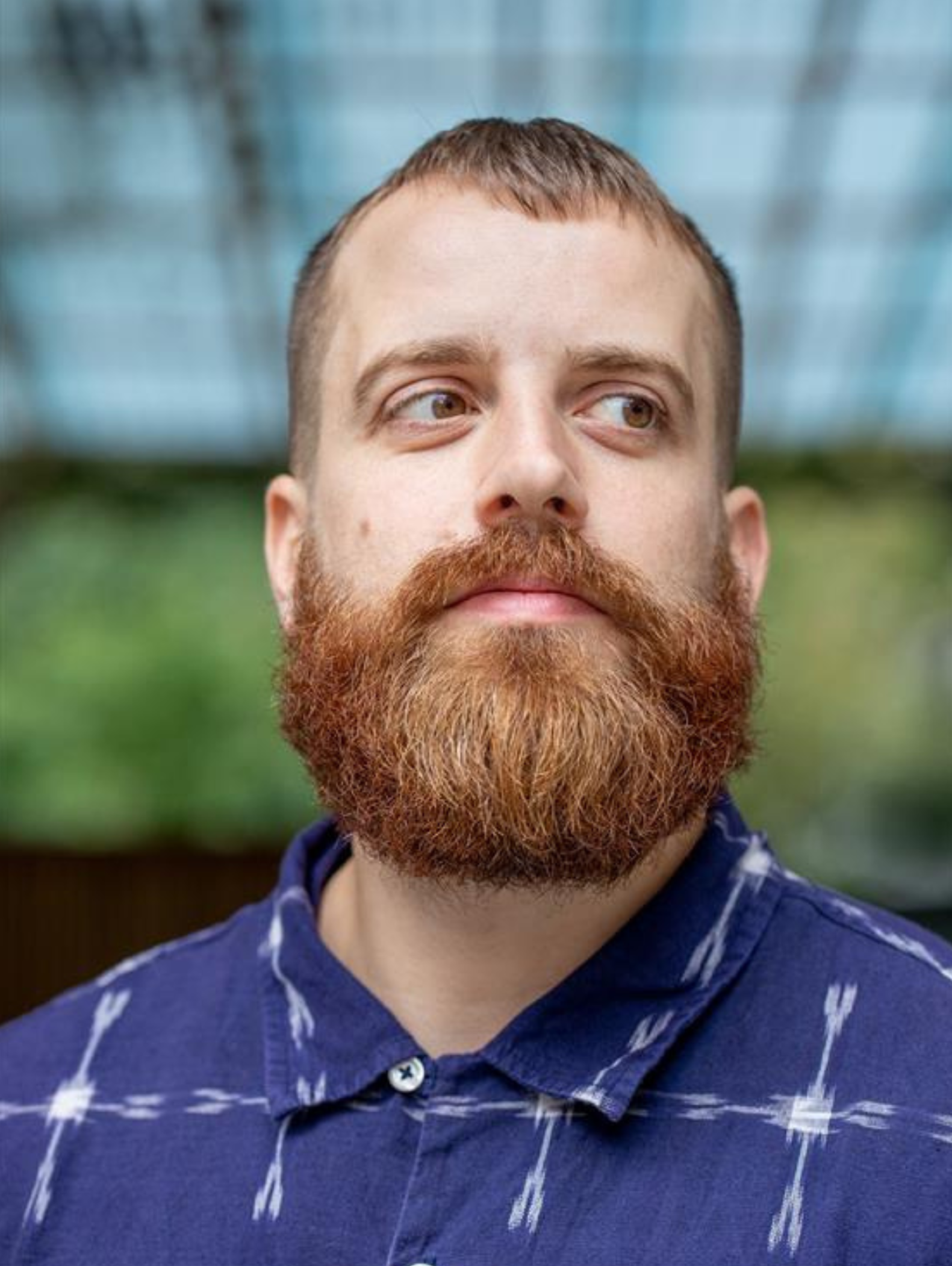 Nando von Arb, ein Mann roten Haaren und Bart im blauem Hemd.