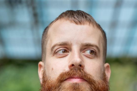 Nando von Arb, ein Mann roten Haaren und Bart im blauem Hemd.