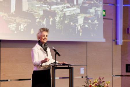 Regierungsrätin Carmen Walker Späh steht in weissem Blazer auf einer Bühne und spricht in ein Mikrofon.