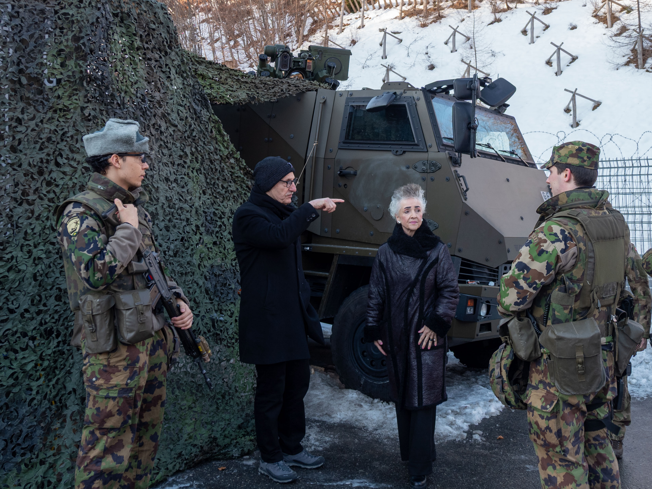 Die Regierungsräte Carmen Walker Späh und Mario Fehr im Gespräch mit Soldaten. Sie stehen vor einem Fahrzeug der Armee, welches mit Tarnnetzen bedeckt wurde.