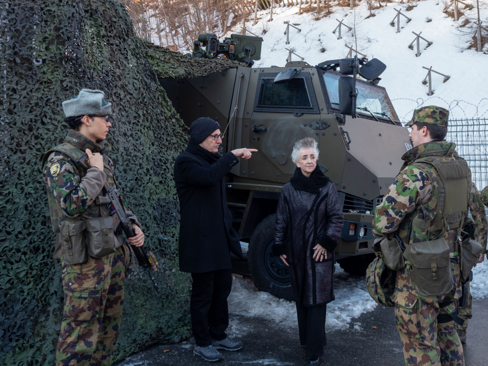 Die Regierungsräte Carmen Walker Späh und Mario Fehr im Gespräch mit Soldaten. Sie stehen vor einem Fahrzeug der Armee, welches mit Tarnnetzen bedeckt wurde.