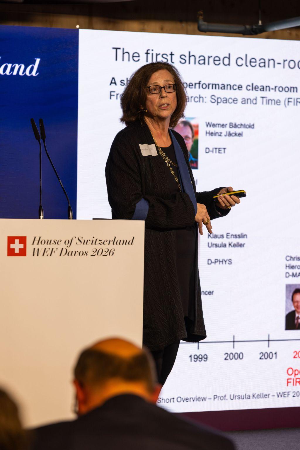 Eine Frau mit Armschlinge präsentiert auf einem Podium