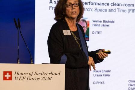 Eine Frau mit Armschlinge präsentiert auf einem Podium