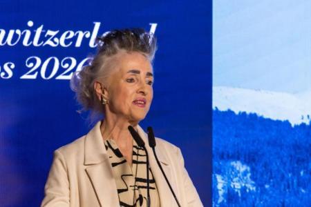 Eine Frau im Blazer hält eine Rede am Podium