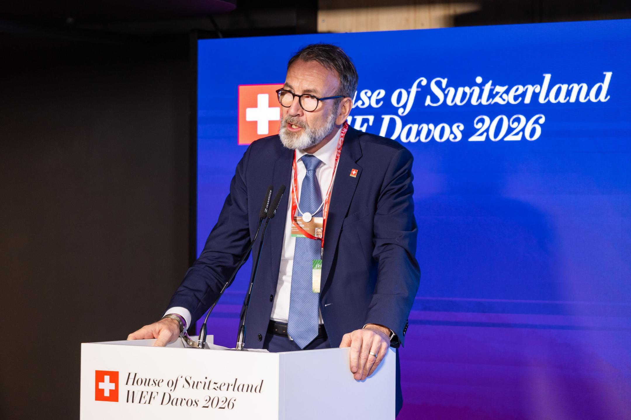 Mann im Anzug hält Rede auf einem Podium