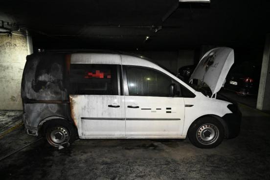 weisses Fahrzeug mit verkohltem Heck steht in einer dunklen Tiefgarage