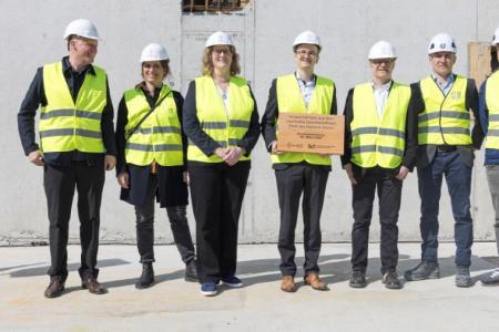 Die Plakette erinnert daran, dass das Gebäude mit lokalem kantonseigenem Holz aus dem Staatswald erstellt wird und somit zu einer nachhaltigen Bauweise beiträgt.