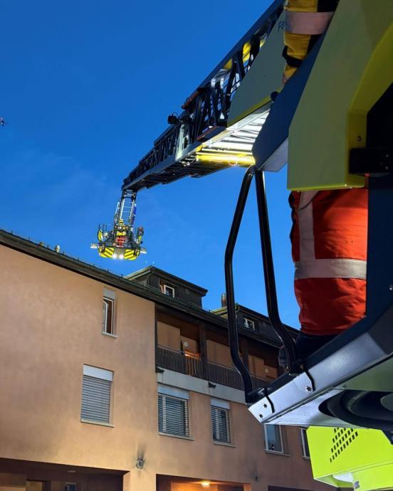 Drehleiter und im Hintergrund ein Mehrfamilienhaus