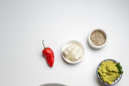 Schale mit Chili sin Carne aus Bohnen, Mais und Gemüse, serviert mit Tortilla-Chips und Beilagen.