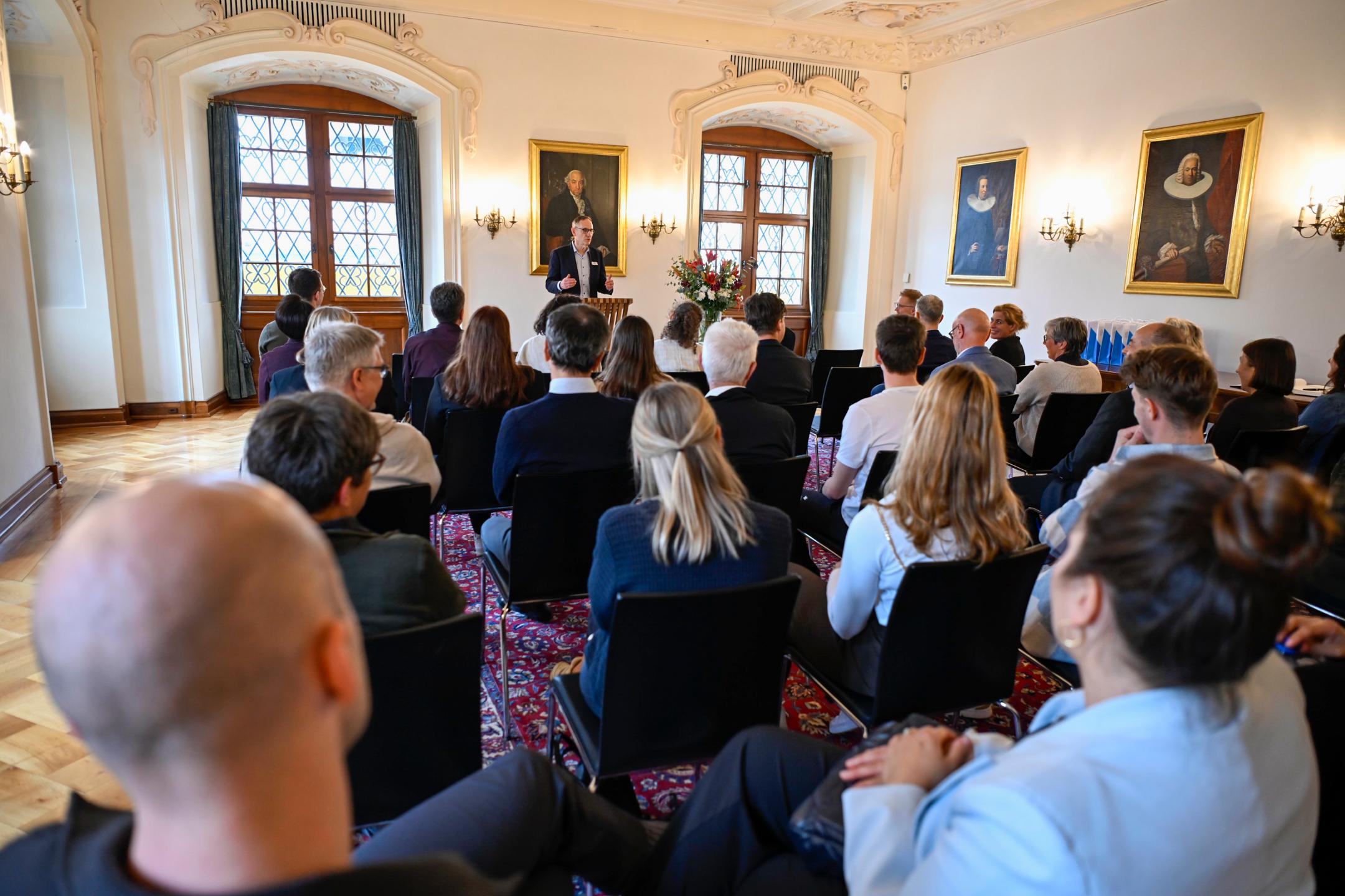 Ein festlicher Saal mit 40 sitzenden Personen mit Blick nach vorne.