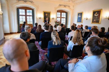 Ein festlicher Saal mit 40 sitzenden Personen mit Blick nach vorne.