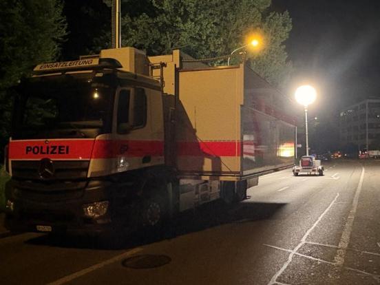 Der Lastwagen (Mobile Einsatzzentrale) der Kantonspolizei auf der Strasse und ein Beleuchtungsballon im Hintergrund