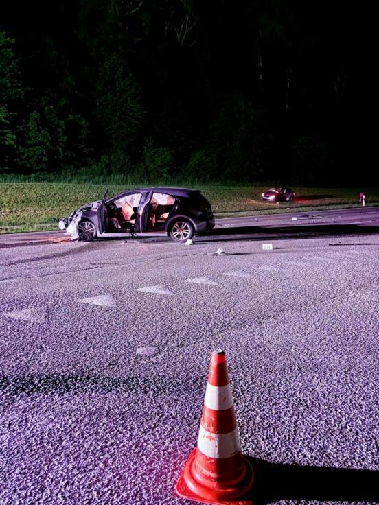 Ein beteiligtes Auto steht stark beschädigt auf der Kreuzung, das andere im Wiesland gegenüber
