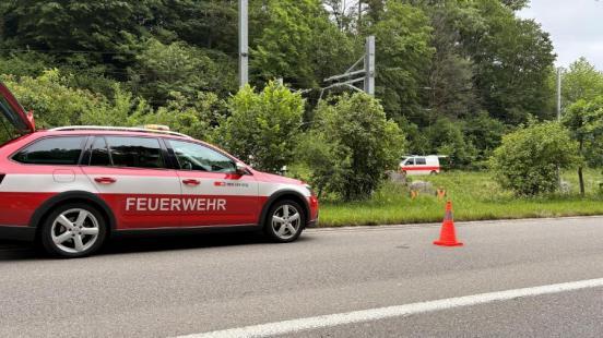 Ein PW der Feuerwehr an einer Bahnlinie, im Hintergrund ein Polizeifahrzeug