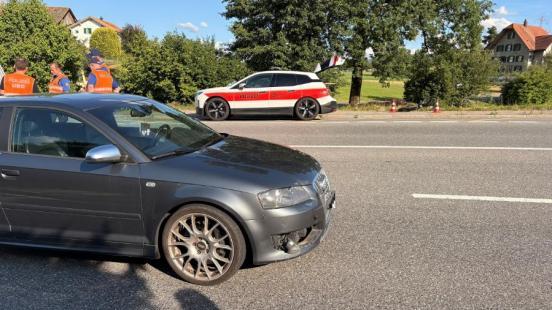Unfallauto auf der Zugerstrasse, im Hintergrund Polizisten, ein Polizeiauto und das Unfallvelo