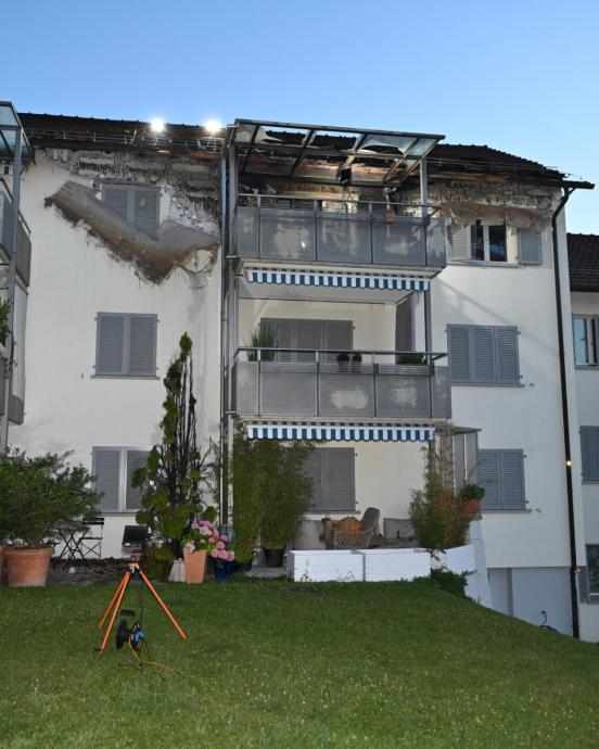 Drei Balkone, am obersten hat es Brandschäden und an Fassade und Dach