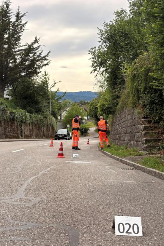 Zwei Unfallspezialisten der Kantonspolizei fotografieren den Strassenrand