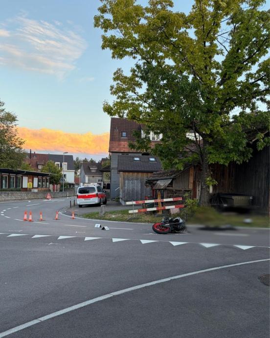 Ein Motorrad liegt auf der Strasse neben Absperrkegeln und einem Polizeiauto
