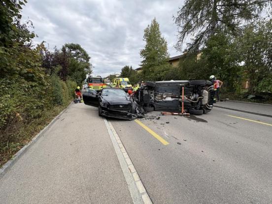 Ein beschädigtes Auto steht mit der Front zur Kamera, daneben liegt ein Auto auf der Seite