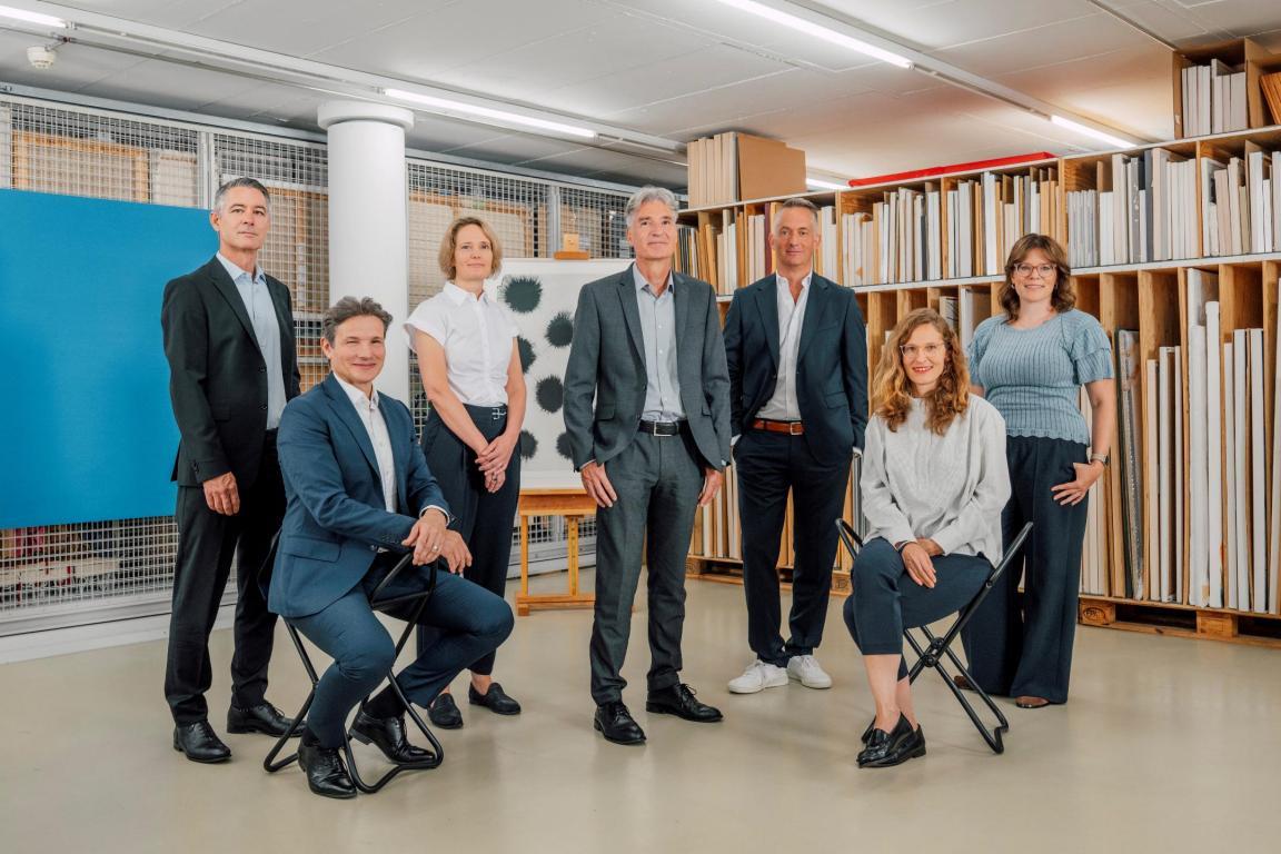 Auf dem Bild sieht man die sieben Mitglieder der Geschäftsleitung in der Kunstsammlung des Kanton Zürichs. Von links nach rechts ist zu sehen, Adriano Tettamanti, Salvatore Talerico, Regula Imhof, Beat Pahud, Claus Frei, Rhea Lesniak-Winkler, Sabrina Walti.
