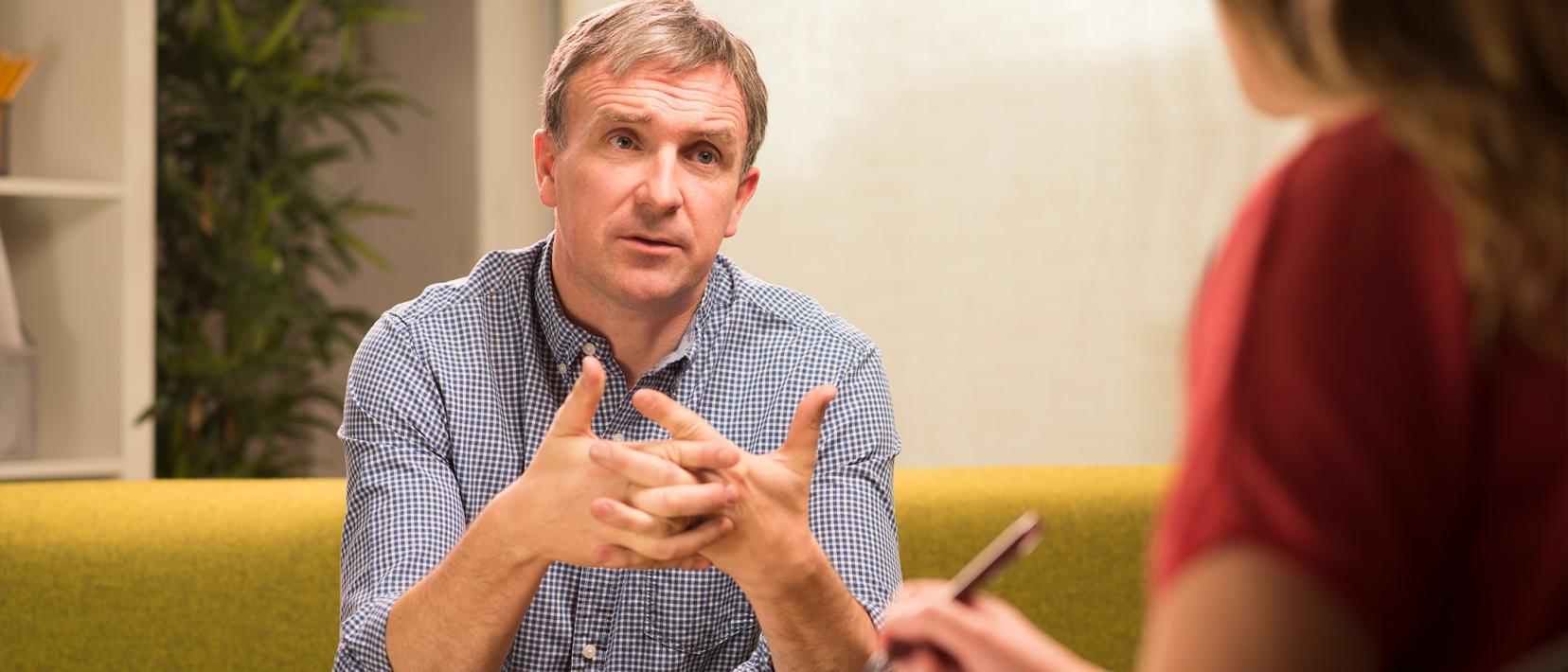 Ein Mann sitzt in einer Beratung. 