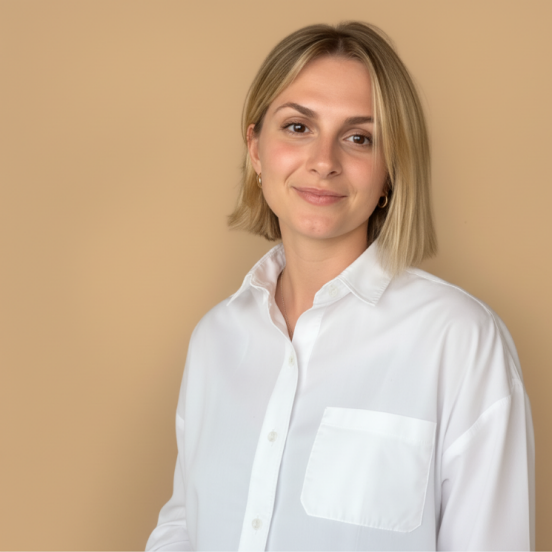 joy trägt eine weisse Bluse und lächelt in die Kamer