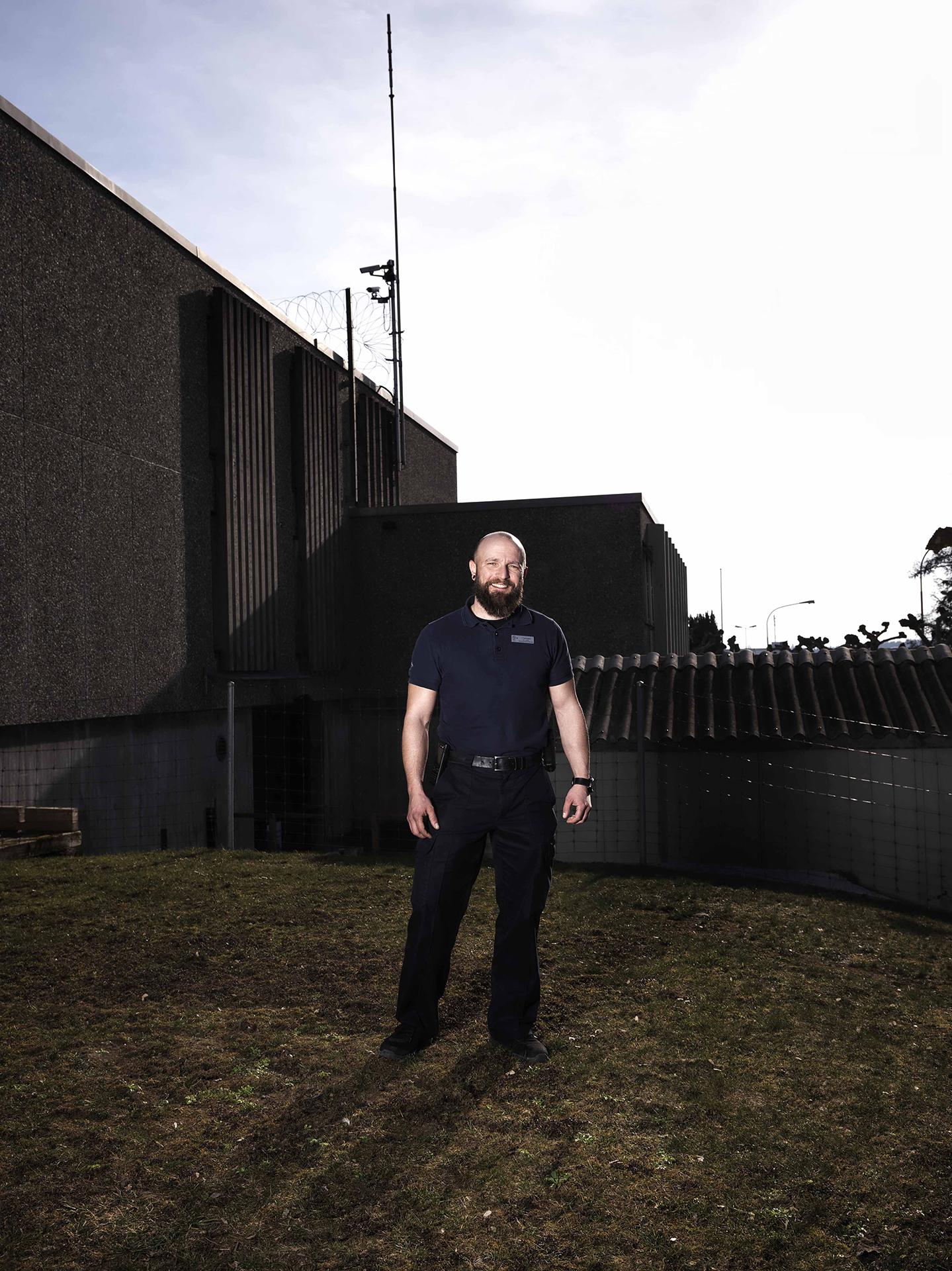 Fachmann Justizvollzug steht neben dem Gefängnis