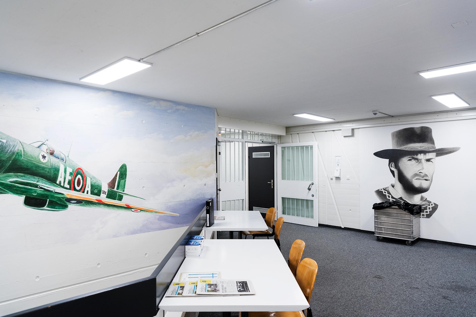 Korridor mit Wandbemalung, Tischen und Stühlen