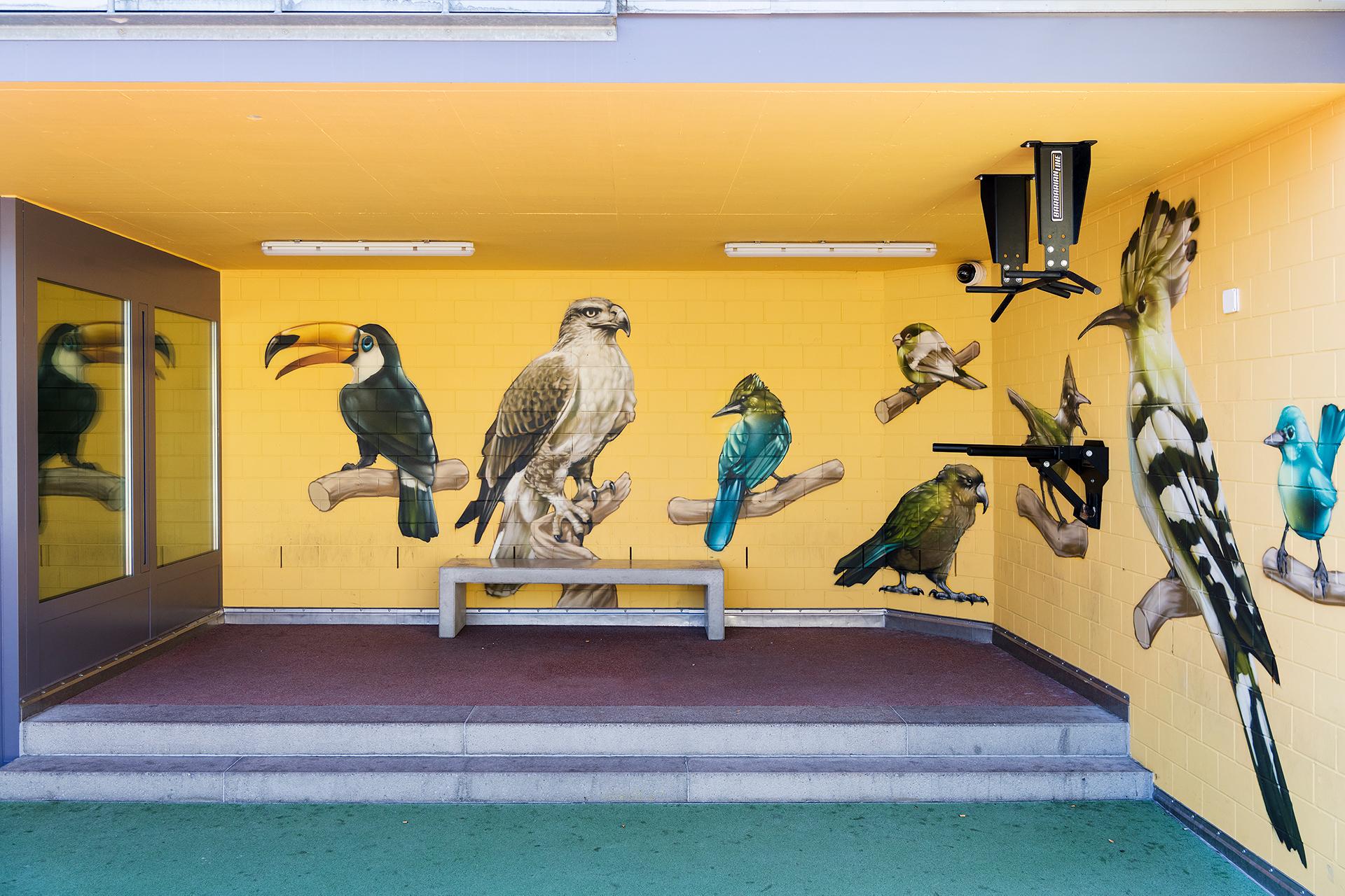 Überdachter Hofplatz mit bunter Wandbemalung, Sitzbank und Fitnessgerät