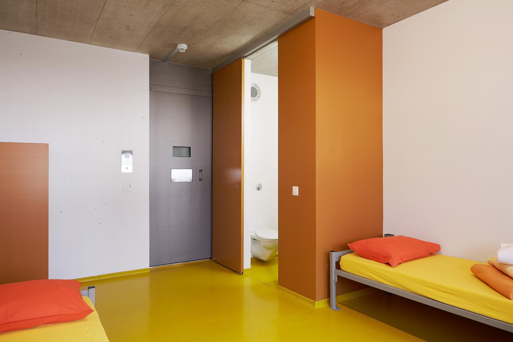 Raum mit zwei Betten, Türe und Badezimmer