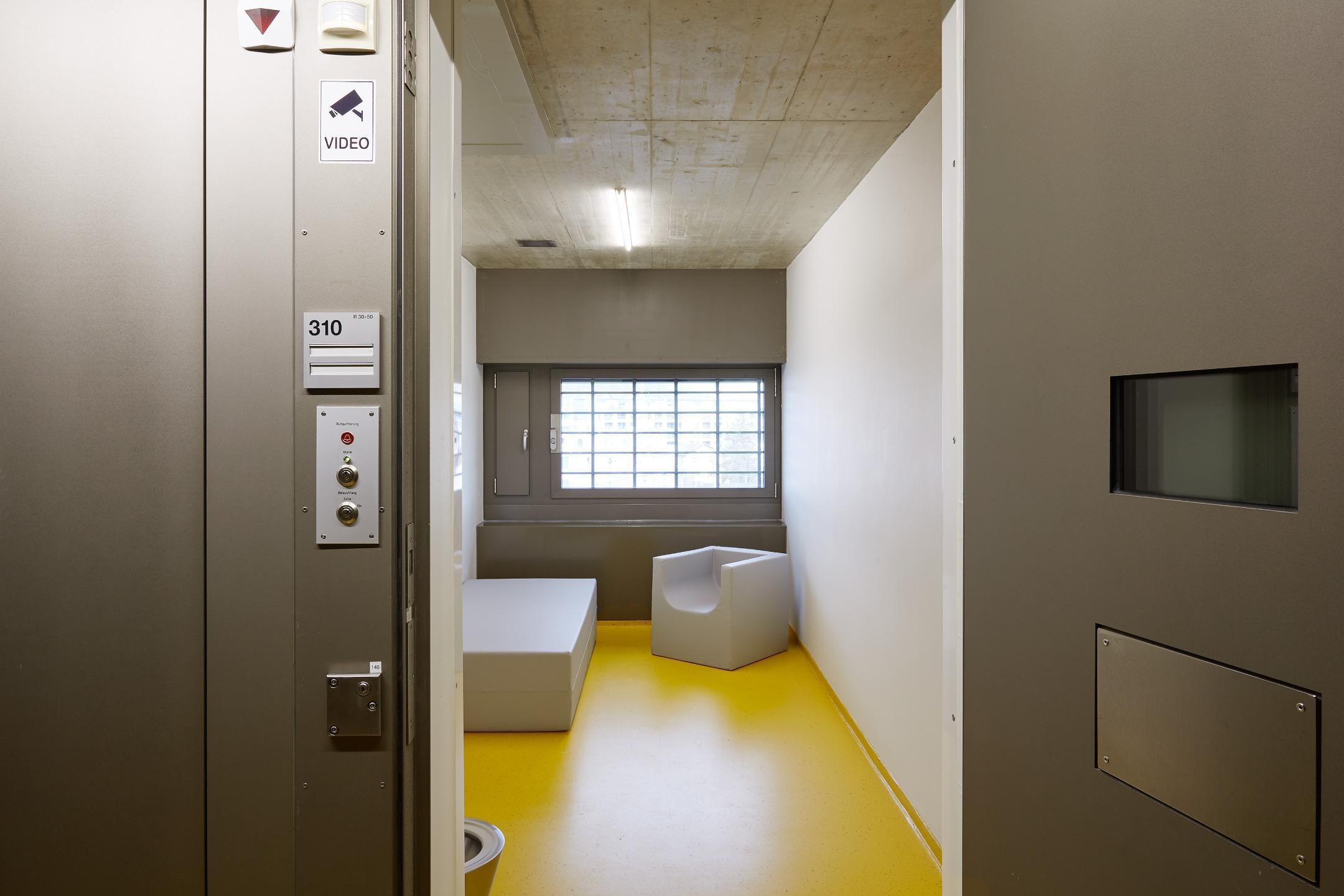 Kleiner, kahler Raum mit Toilette und Sitzgelegenheit