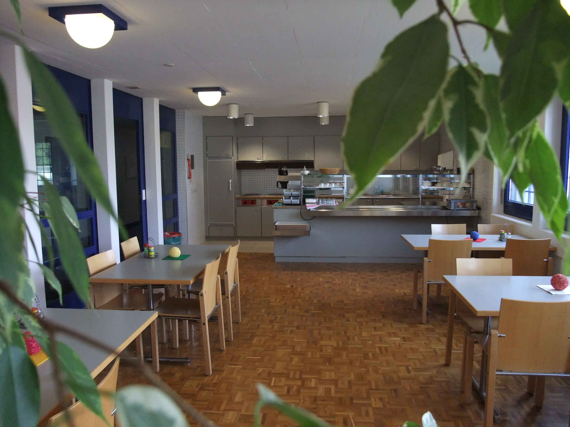 Essraum mit Tischen und jeweils vier Stühlen.