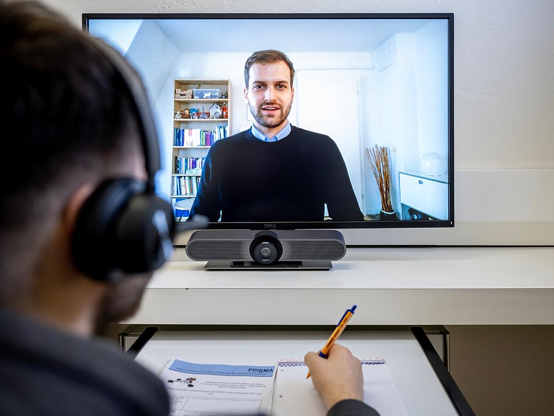 Ein Inhaftierter telefoniert per Video.