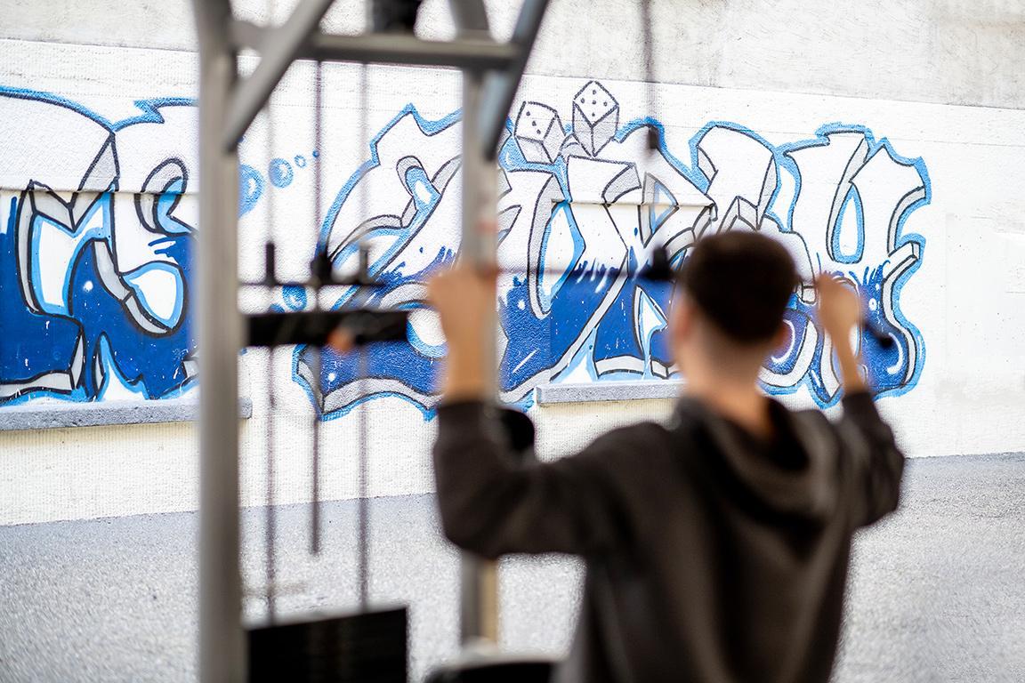 Ein inhaftierter Mann trainiert an einer Gewichtsmaschine auf dem Innenhof des Gefängnisses.